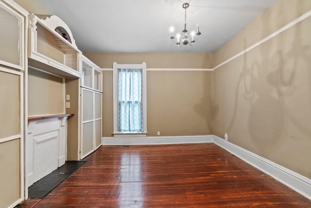 spacious closet featuring an inviting chandelier and dark wood-style flooring