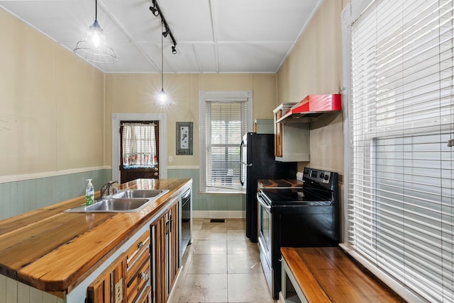 kitchen with track lighting, a sink, dishwasher, butcher block countertops, and range with electric cooktop