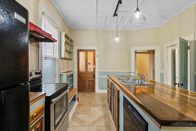 kitchen featuring butcher block countertops, track lighting, a sink, and black appliances