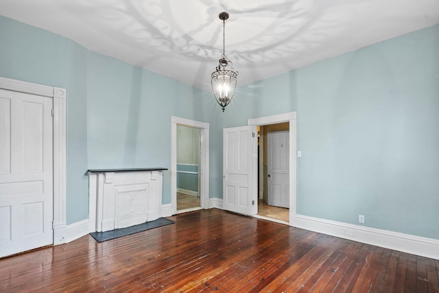 interior space with baseboards, hardwood / wood-style flooring, and a notable chandelier