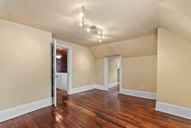 bonus room featuring baseboards, vaulted ceiling, visible vents, and hardwood / wood-style floors