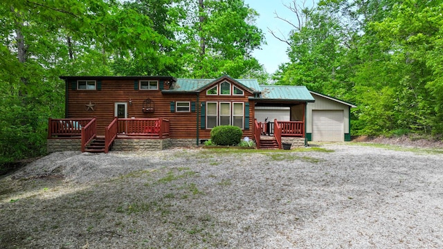rustic home with a garage, a wooden deck, faux log siding, and metal roof