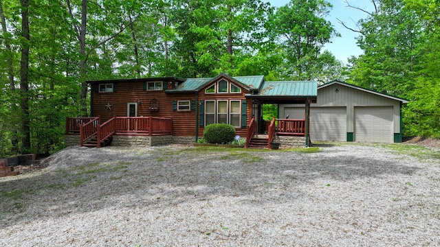chalet / cabin featuring log veneer siding, a deck, metal roof, and a garage