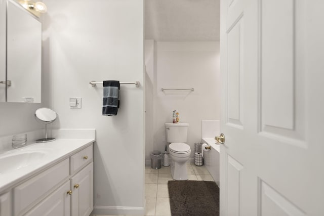 bathroom with a bath, tile patterned floors, baseboards, vanity, and toilet