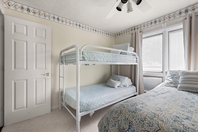 bedroom featuring carpet floors, a ceiling fan, a textured ceiling, and baseboards