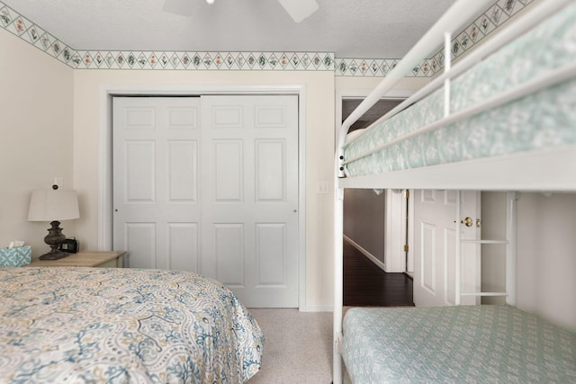 bedroom with a closet, a ceiling fan, baseboards, and carpet floors