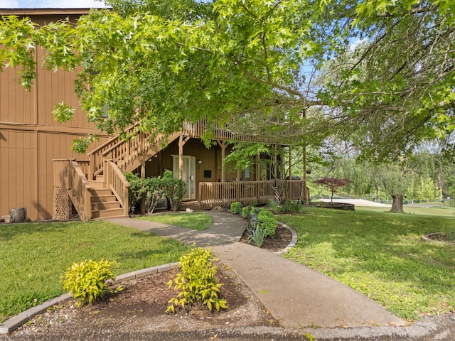 view of property hidden behind natural elements with a porch, a front lawn, and stairway