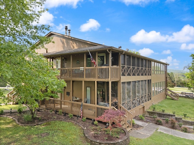 back of property featuring a yard and a sunroom