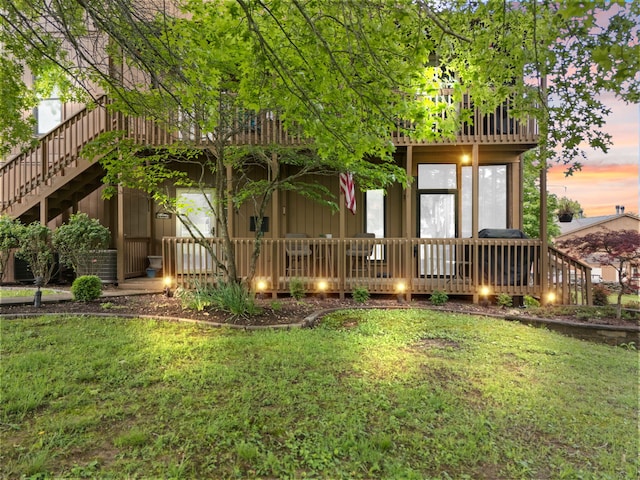 back of house at dusk with a lawn