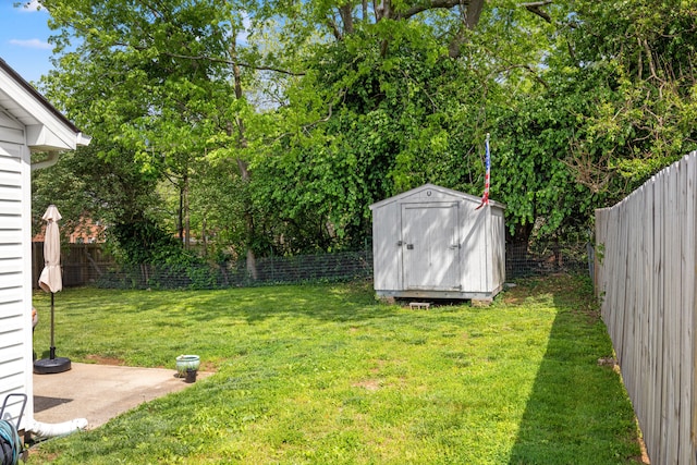 view of yard with a storage unit, a fenced backyard, and an outdoor structure
