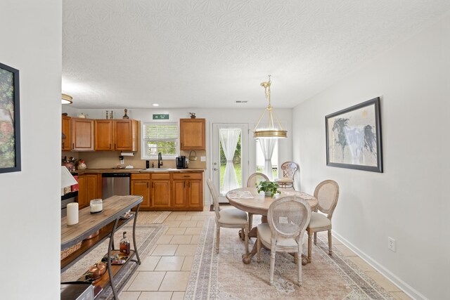 dining area with light tile patterned flooring, a textured ceiling, visible vents, and baseboards