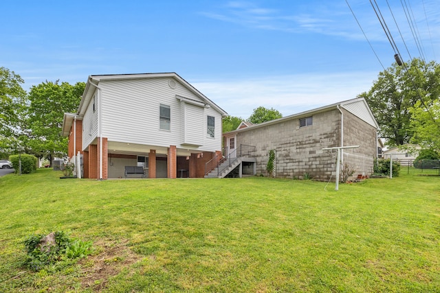 107 Highview Dr, Midway, KY 40347 - back of property featuring a lawn, fence, and stairs