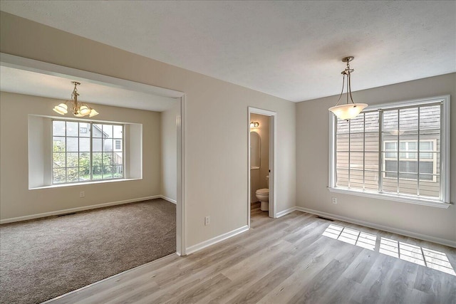 1148 Oatlands Park, Lexington, KY 40509 - unfurnished dining area with an inviting chandelier, baseboards, light wood-style flooring, and visible vents