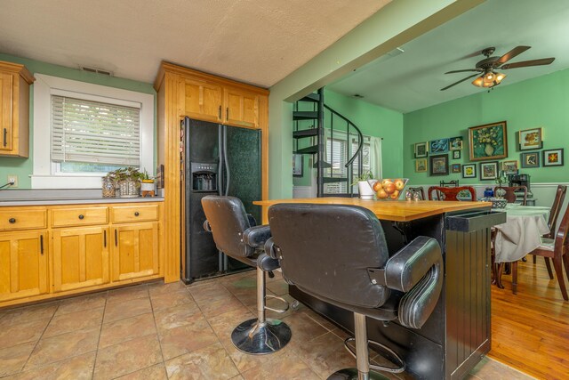 363 S Main St, Winchester, KY 40391 - kitchen featuring butcher block countertops, black fridge with ice dispenser, a ceiling fan, and visible vents