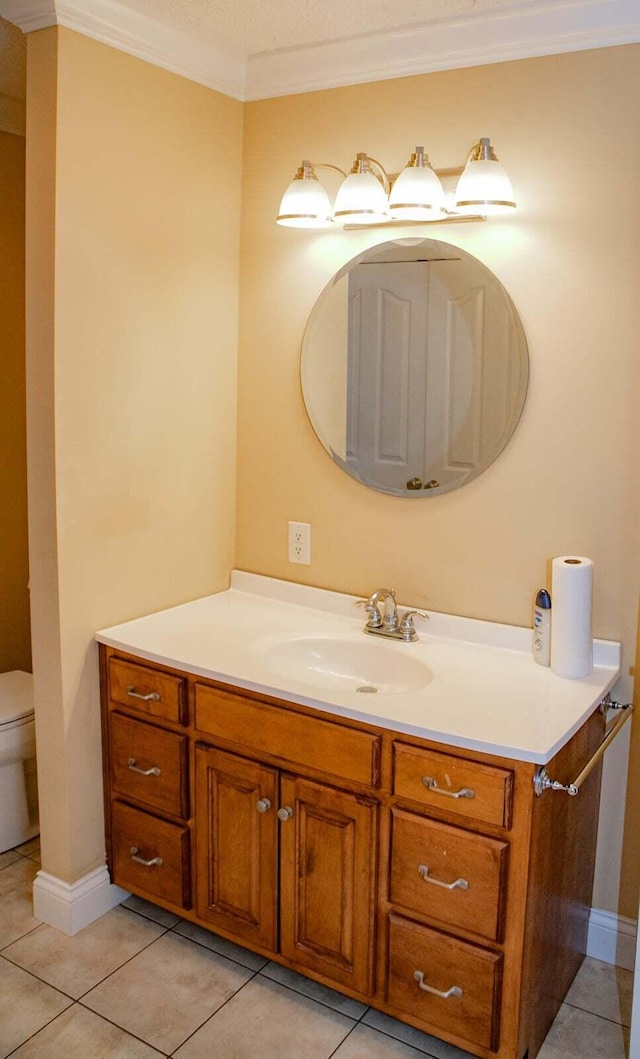 bathroom with vanity, ornamental molding, tile patterned flooring, and toilet