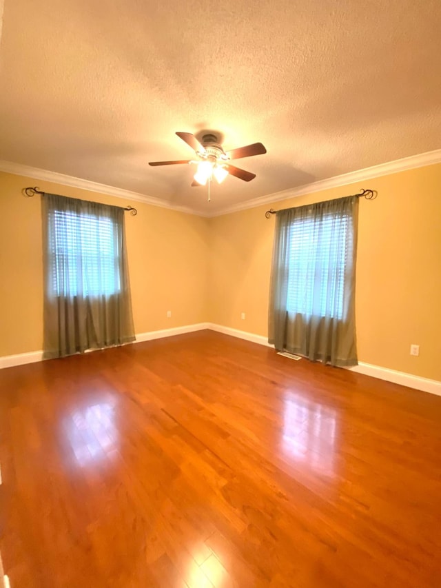 unfurnished room featuring a textured ceiling, ceiling fan, ornamental molding, and wood finished floors