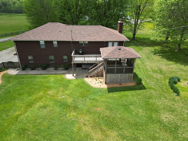 back of property with stairs, a wooden deck, a yard, and a chimney