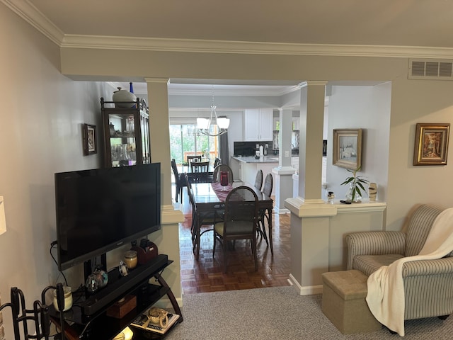living room featuring crown molding, decorative columns, a chandelier, and visible vents