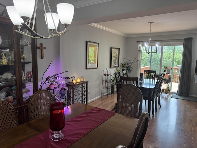 dining room featuring an inviting chandelier, ornamental molding, baseboards, and wood finished floors