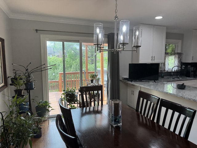 dining space featuring an inviting chandelier, recessed lighting, crown molding, and wood finished floors