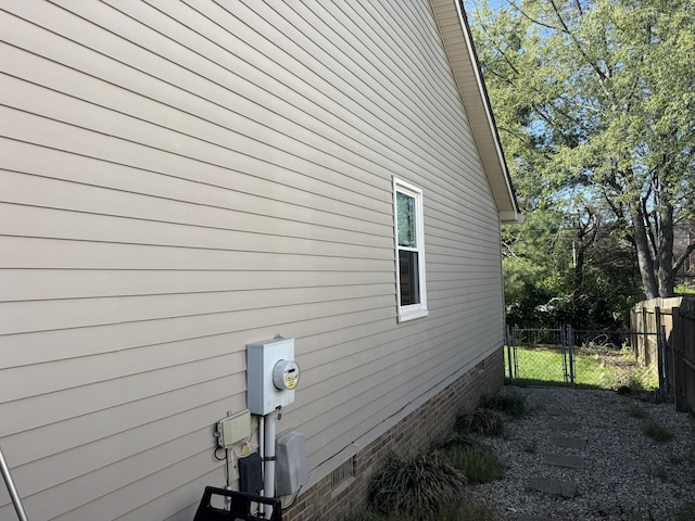 view of property exterior with fence, a gate, and crawl space