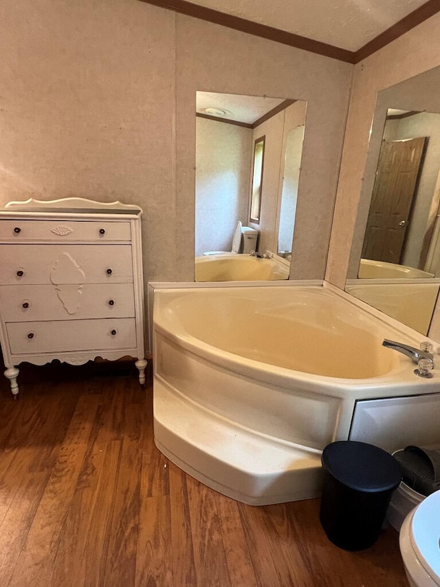 bathroom with crown molding and wood finished floors