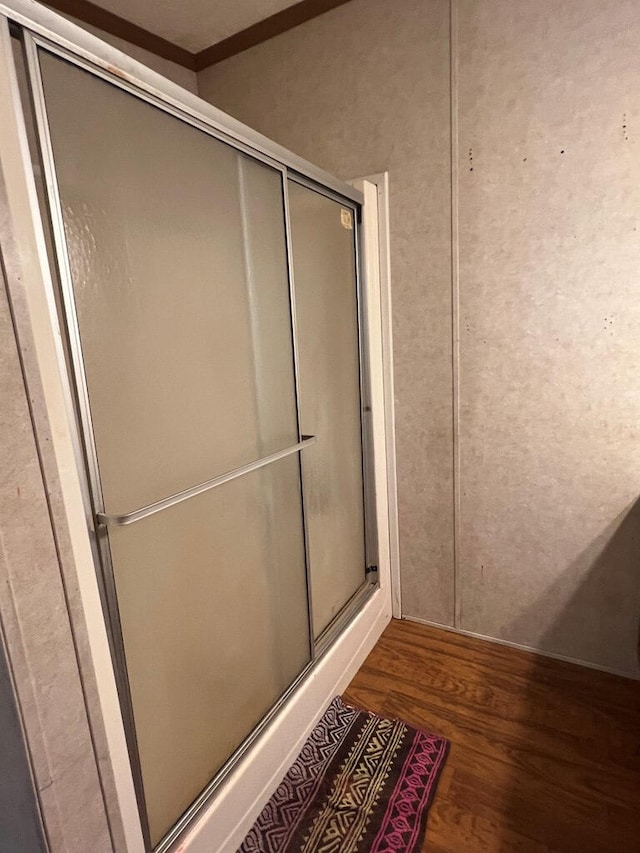 full bath with an enclosed shower and wood finished floors
