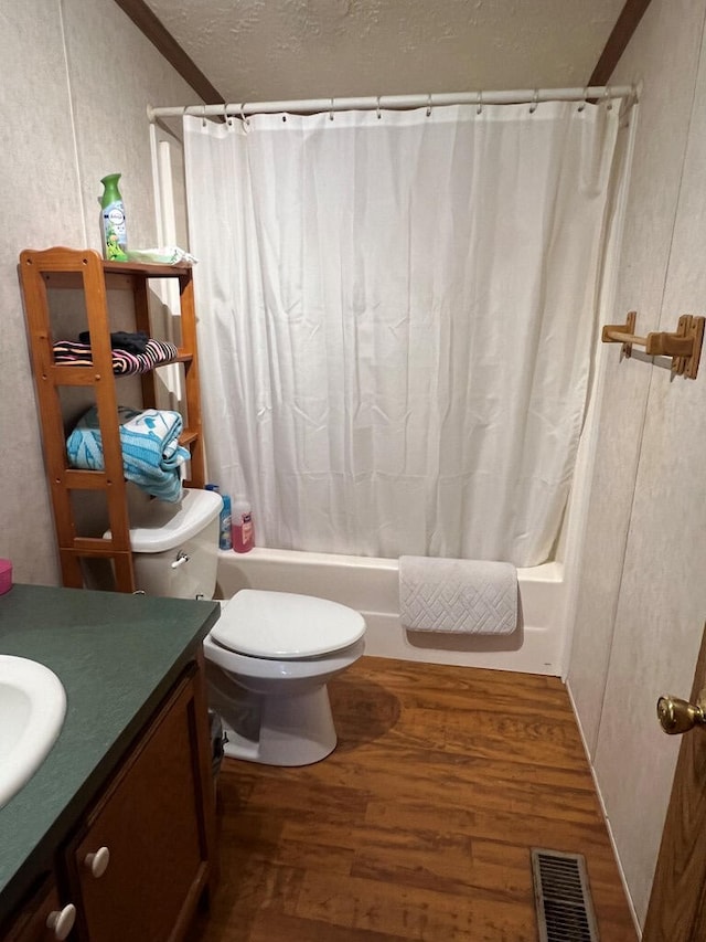 full bathroom with vanity, shower / bath combination with curtain, wood finished floors, and visible vents