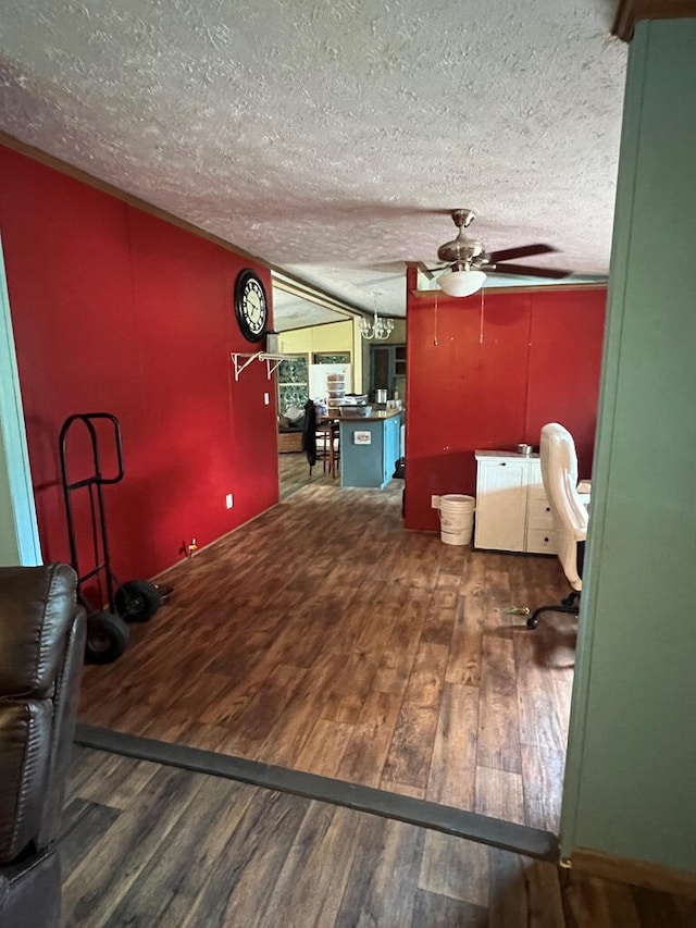 interior space with a textured ceiling, ceiling fan, and wood finished floors