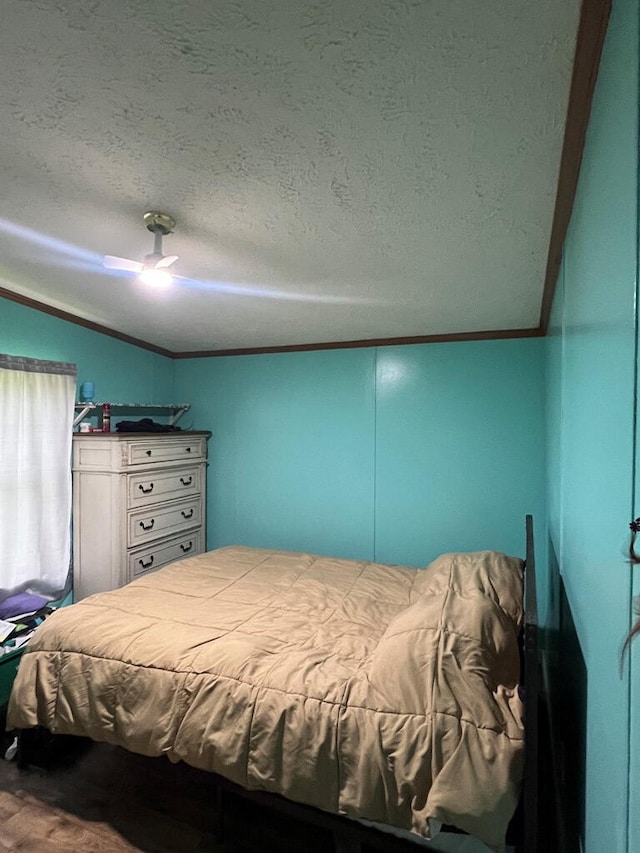 bedroom with ceiling fan, lofted ceiling, a textured ceiling, and wood finished floors