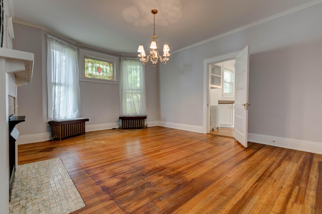 unfurnished dining area with baseboards, a notable chandelier, ornamental molding, and hardwood / wood-style flooring