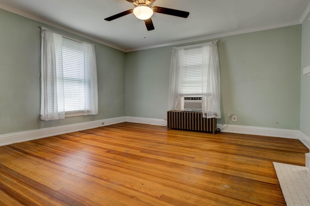 empty room with radiator heating unit, baseboards, ceiling fan, and hardwood / wood-style floors