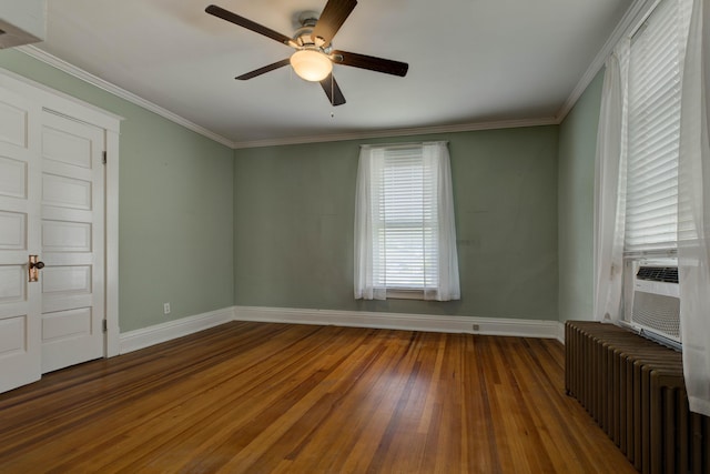 empty room featuring ceiling fan, wood finished floors, baseboards, cooling unit, and radiator heating unit