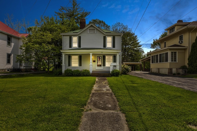 traditional-style house featuring a porch, a chimney, and a front lawn