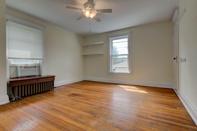 unfurnished room with wood-type flooring, ornamental molding, radiator, baseboards, and cooling unit