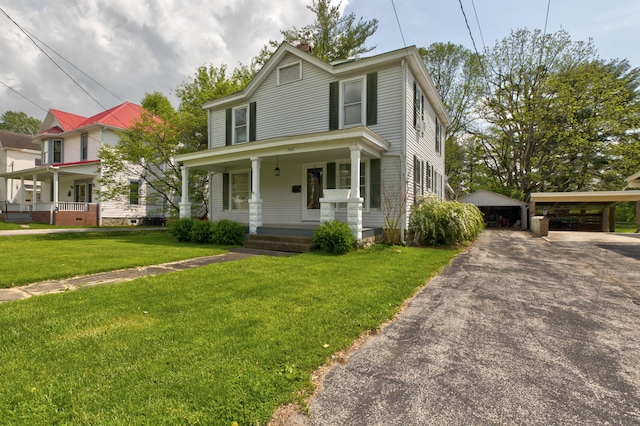 view of front of property with a garage, a front lawn, an outbuilding, and covered porch
