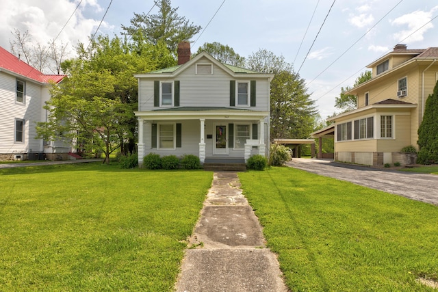 traditional home featuring a porch, a front lawn, and a chimney