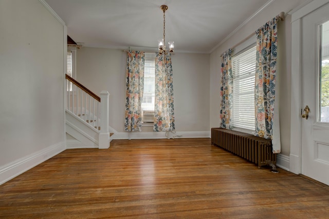 unfurnished dining area with wood finished floors, stairs, radiator heating unit, and a notable chandelier