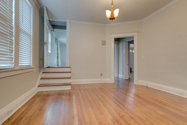spare room with crown molding, stairs, baseboards, a chandelier, and light wood-style flooring