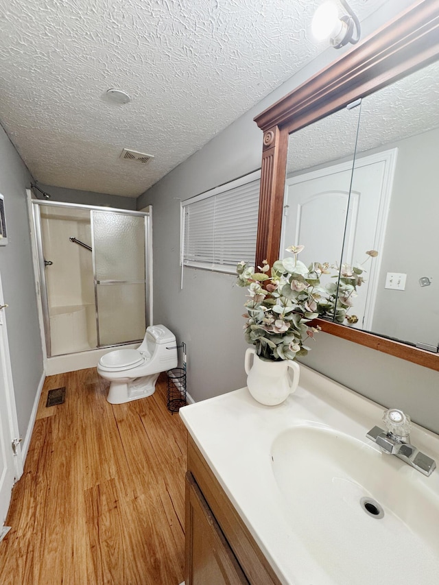 187 Sinnette, Greenup, KY 41144 - bathroom featuring a textured ceiling, visible vents, an enclosed shower, wood finished floors, and vanity