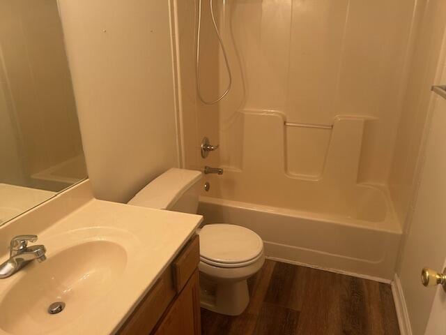 full bath featuring vanity, toilet, wood finished floors, and shower / tub combination