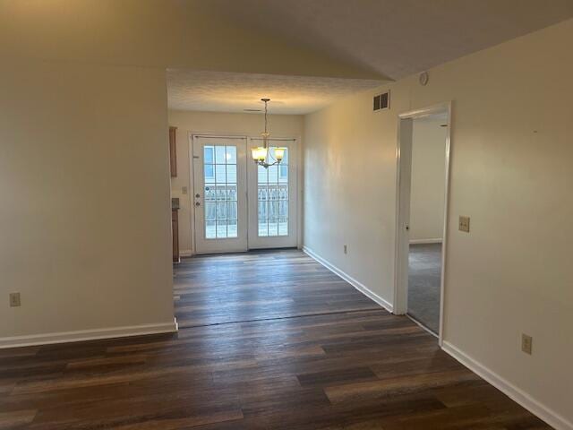 unfurnished dining area featuring visible vents, baseboards, a chandelier, and dark wood finished floors