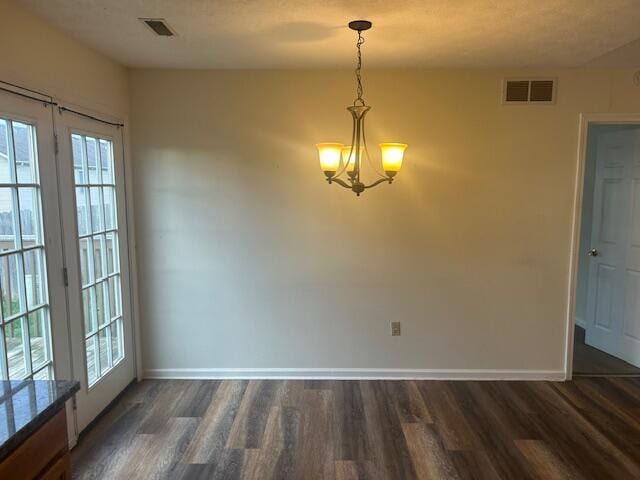unfurnished dining area featuring baseboards, dark wood-type flooring, and visible vents