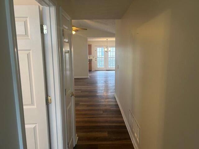 hall featuring baseboards, visible vents, and dark wood-style floors