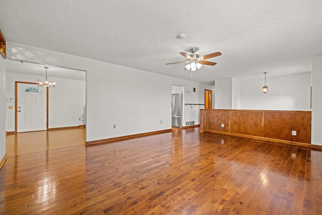 140 Adams Ln, Richmond, KY 40475 - unfurnished living room featuring hardwood / wood-style floors, a textured ceiling, a ceiling fan, a wainscoted wall, and a chandelier