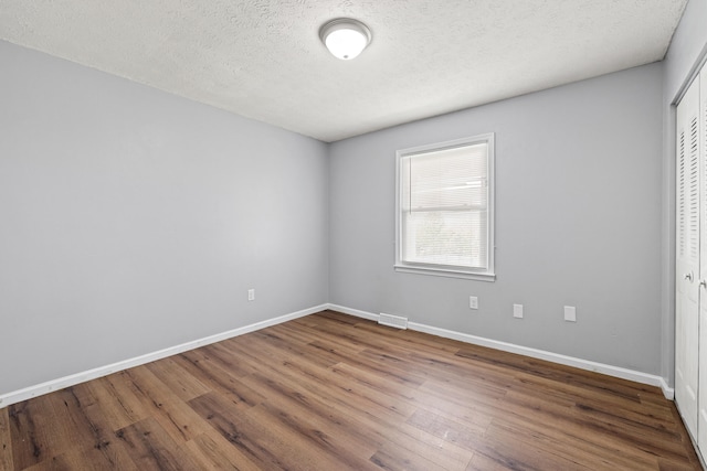 unfurnished bedroom with baseboards, a closet, and wood finished floors
