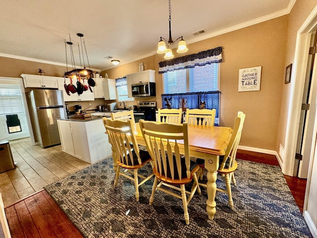 310 W Chestnut St, Nicholasville, KY 40356 - dining space with a chandelier, light wood-style flooring, and crown molding