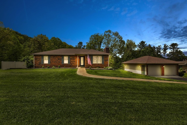 ranch-style home featuring a chimney, a detached garage, fence, an outdoor structure, and a front lawn