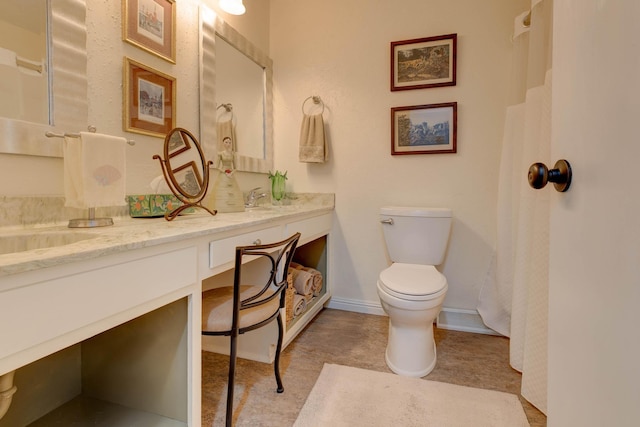 full bathroom featuring vanity, baseboards, and toilet