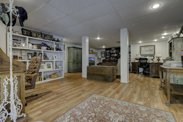 interior space featuring light wood finished floors and a drop ceiling